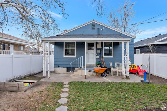 Rear view of house featuring a yard, a patio area, a shingled roof, and a fenced backyard | Image 16