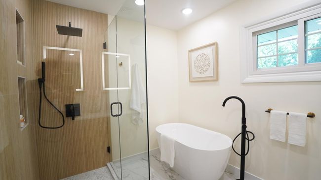 The owners' bath has been totally remodeled to allow for a large shower, a freestanding tub, beautiful tile work, ample amounts of lighting and a custom glass shower surround. | Image 11