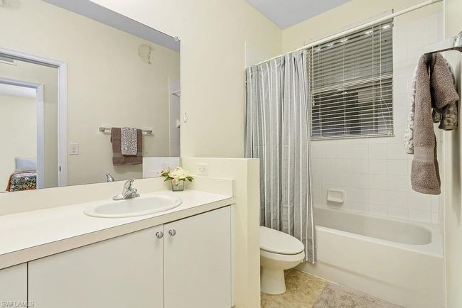 Bathroom featuring shower / tub combo, toilet, tile patterned flooring, and vanity | Image 21