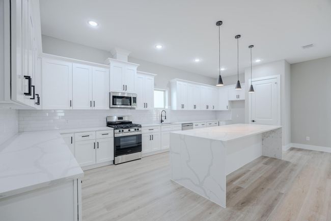 Modern kitchen features high-end finishes and an oversized islandModern kitchen features high-end finishes and an oversized island | Image 16