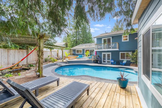View of pool with a fenced in pool, a diving board, french doors, a fenced backyard, and a wooden deck | Image 34
