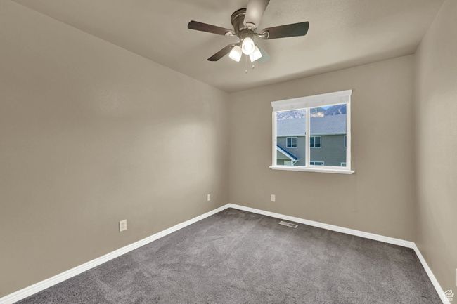 Unfurnished room with dark colored carpet and ceiling fan | Image 19
