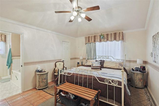 Spacious primary suite tucked away in a private split floor plan, featuring ceramic tile flooring, abundant natural light, and room to create a relaxing retreat. | Image 14