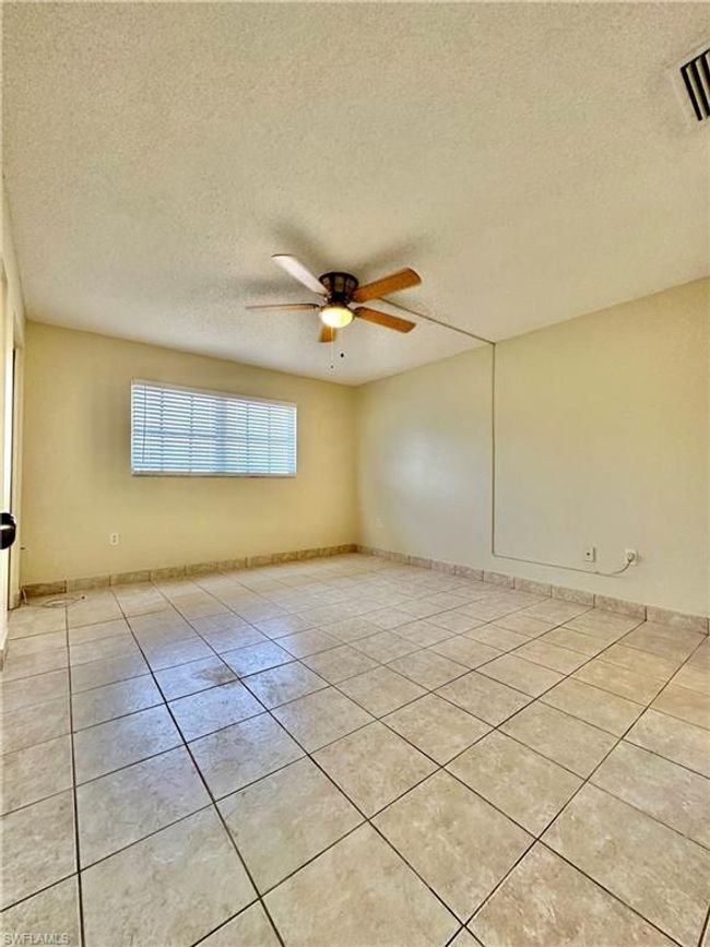 Unfurnished room featuring light tile patterned flooring, a textured ceiling, and a ceiling fan | Image 7