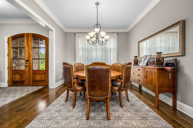 High ceilings and hardwood flooring in a formal dining room create an elegant and inviting atmosphere, perfect for entertaining guests. | Image 32