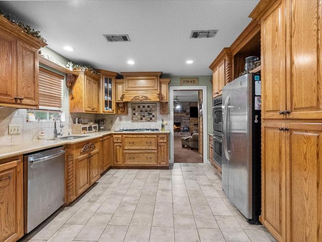 Beautiful rustic kitchen with ample cabinet space and pot filler. | Image 16