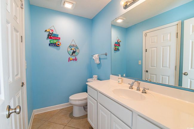 Bathroom with tile patterned flooring, baseboards, vanity, and toilet | Image 36