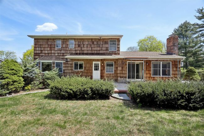 Rear view of house with a chimney, roof with shingles, and a lawn | Image 37