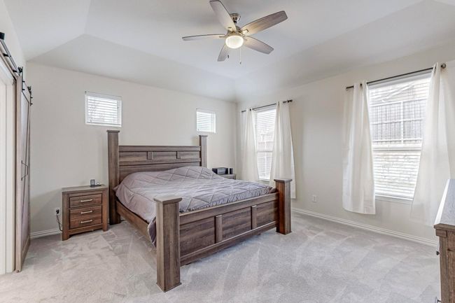 Bedroom with a barn door, light carpet, baseboards, and a ceiling fan | Image 30