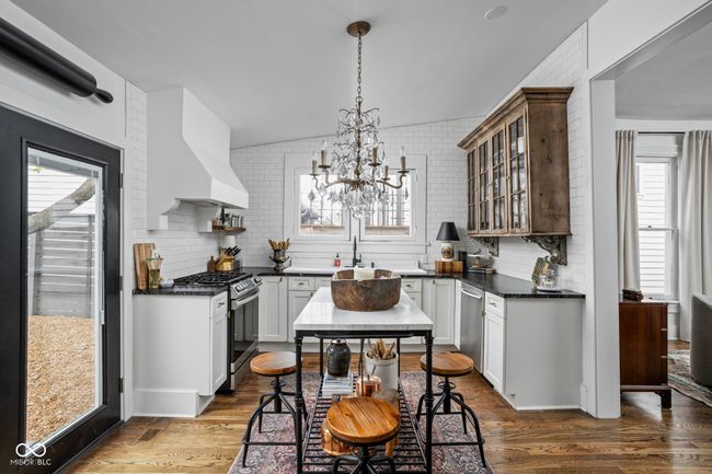 kitchen featuring a healthy amount of sunlight, stainless steel appliances, custom range hood and upper cabinets | Image 15