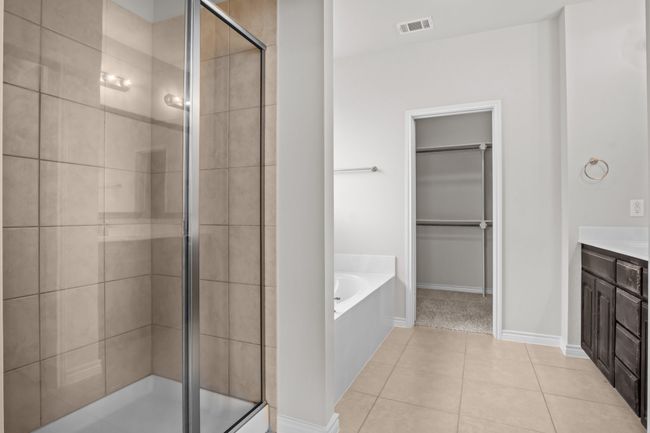 Full bath with a walk in closet, vanity, visible vents, a garden tub, and a stall shower | Image 24