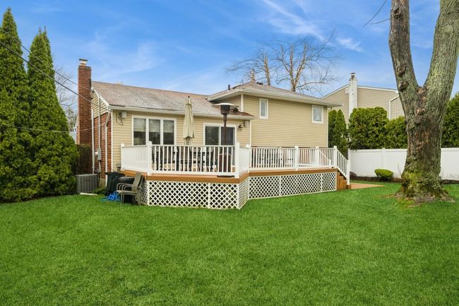 Back of house with a lawn, a chimney, a wooden deck, and fence | Image 25