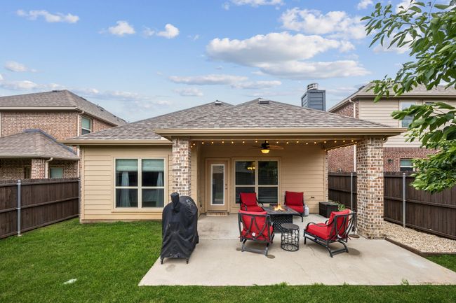 Back of house featuring ceiling fan, a fire pit, a patio, and roof with shingles | Image 27