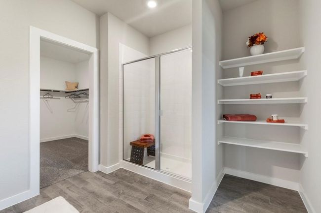 Primary bathroom with tile flooring and a shower with shower door | Image 7