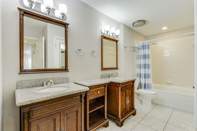 Full bath with a sink, tile patterned flooring, a textured ceiling, and two vanities | Image 19