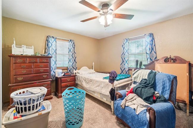 Bedroom featuring multiple windows, carpet flooring, and a ceiling fan | Image 19