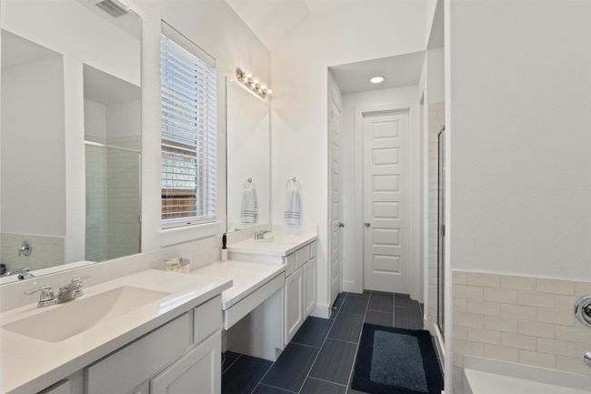 Full bath featuring vanity, a stall shower, tile patterned flooring, and a bath | Image 7