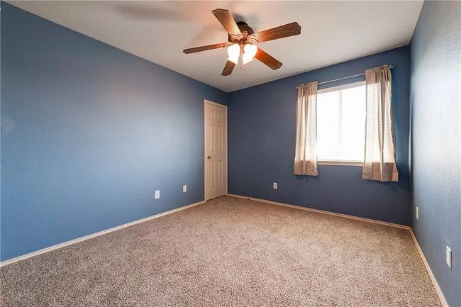 Carpeted spare room featuring a ceiling fan and baseboards | Image 12