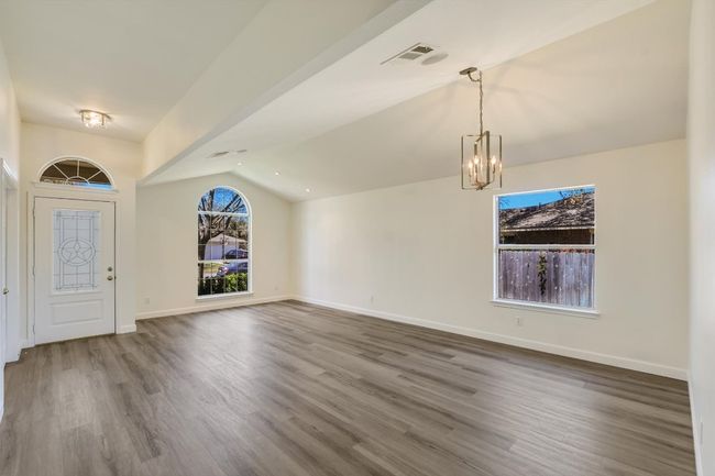 View of the entry, front sitting area and dining area. Note the updated lighting, gorgeous floors and fresh paint! | Image 10