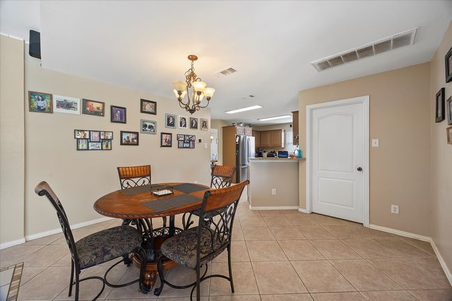 Dining area with a chandelier, light tile patterned flooring, and baseboards | Image 15
