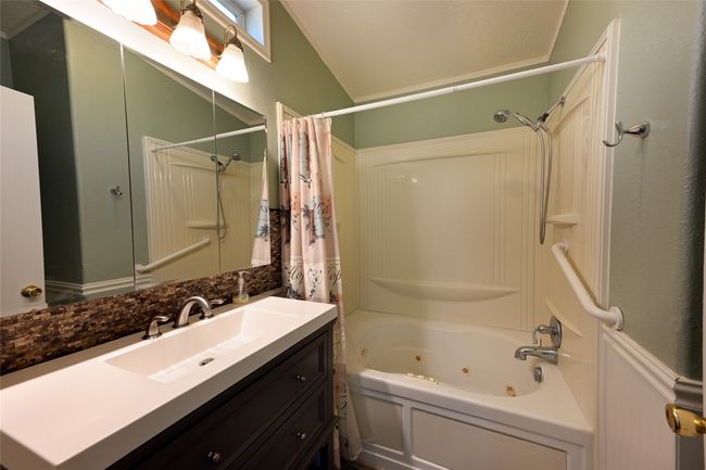 Full bath with a combined bath / shower with jetted tub, vanity, and vaulted ceiling | Image 43