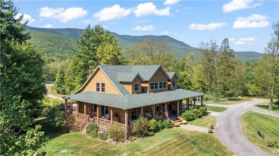 View of front of home featuring a front lawn, covered porch, and a mountain view | Image 1