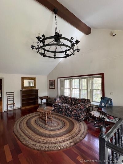 Cathedral Ceiling with hand hewn beams and mantle, floor to ceiling natural stone fireplace. | Image 3