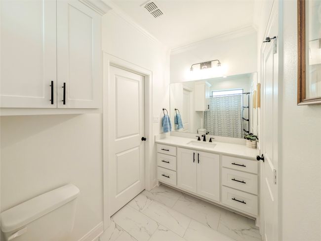 Bathroom with vanity, marble finish floors, crown molding, and a shower | Image 28