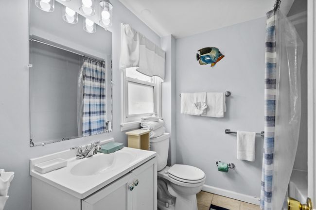 Full bathroom with toilet, vanity, tile patterned flooring, and a shower with shower curtain | Image 14