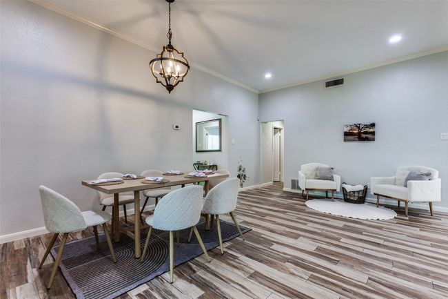 Dining space with a chandelier, light wood-style flooring, ornamental molding, and recessed lighting | Image 12