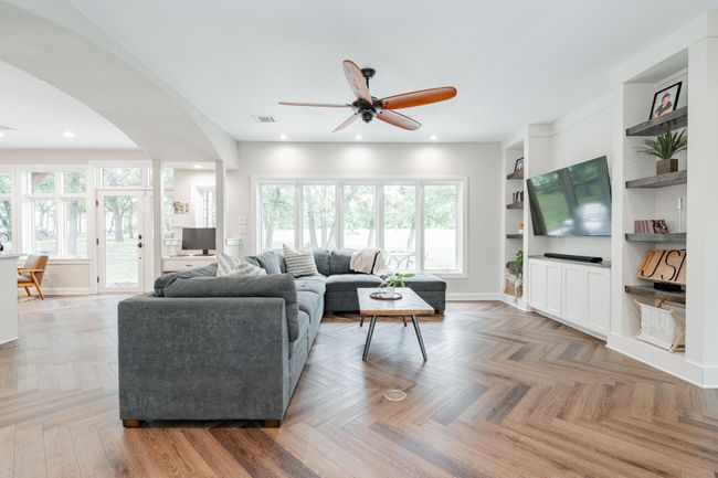 Living room featuring built in features and arched walkways | Image 9