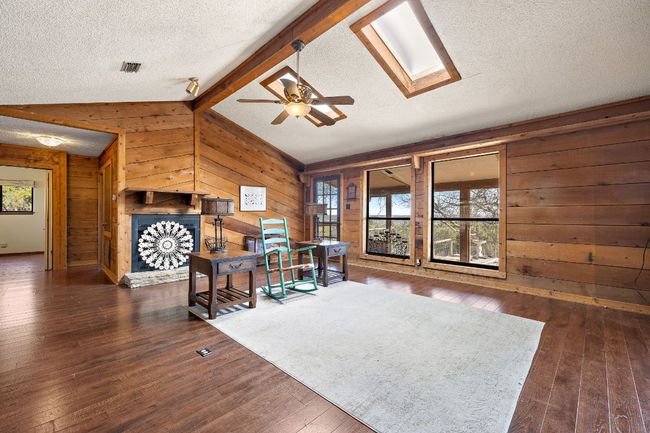 Living room featuring lofted ceiling and wood-burning fire place | Image 11