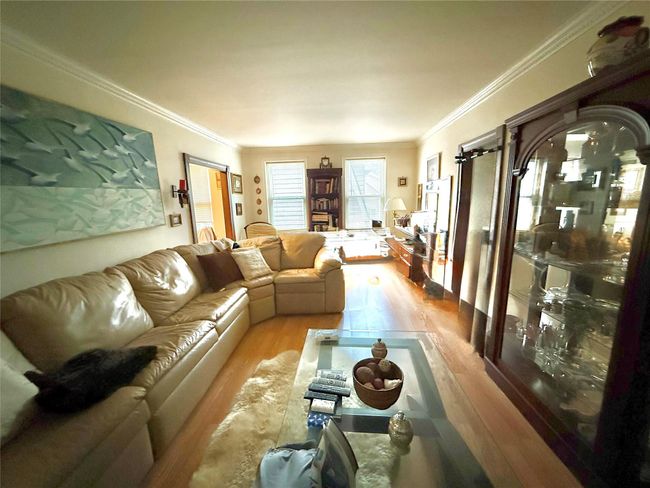 Living area featuring wood finished floors and crown molding | Image 4
