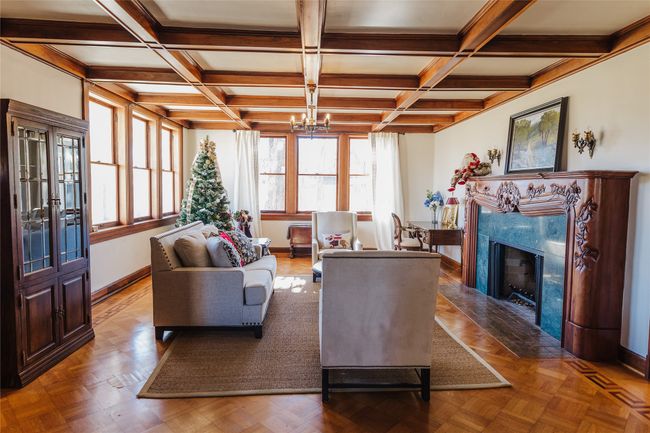Living room with coffered ceiling, parquet floors, beamed ceiling, and a fireplace | Image 6