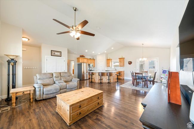 Living room featuring dark wood finished floors, lofted ceiling, and ceiling fan | Image 12