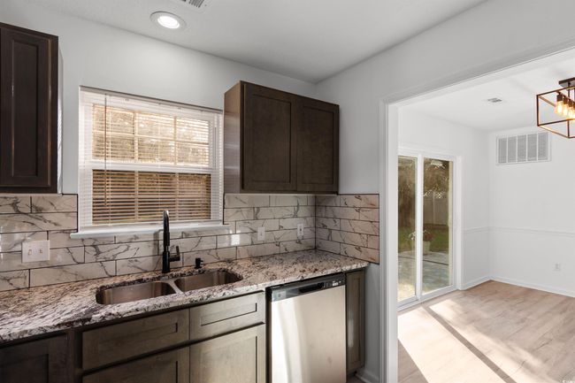 Kitchen featuring stainless steel appliances, a sink, open shelves, and dark brown cabinetry | Image 8
