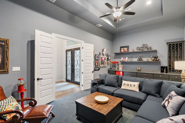 Media room featuring a tray ceiling, French doors, a ceiling fan, and plush theater carpeting. | Image 10