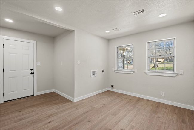 Washroom featuring hookup for a washing machine, visible vents, hookup for an electric dryer, light wood-type flooring, and baseboards | Image 13