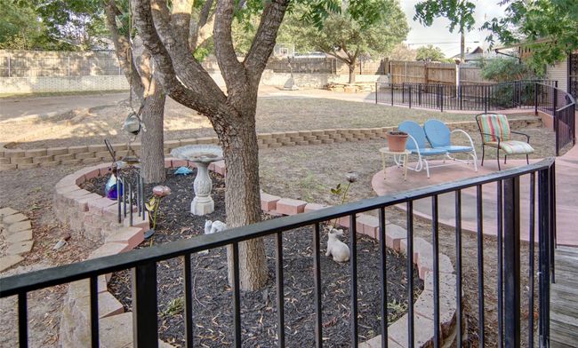 Large fenced backyard with nice shade and sitting areas, private entries to two of the bedrooms, and the driveway circles through from the garage! | Image 30