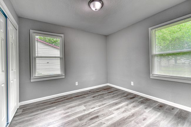 Unfurnished bedroom featuring wood finished floors, a closet, a textured wall, and a textured ceiling | Image 10