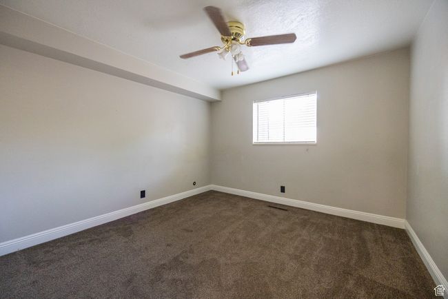 Empty room featuring dark carpet and a ceiling fan | Image 6