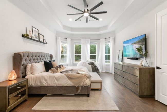 Bedroom with wood finished floors, a tray ceiling, ceiling fan, and recessed lighting | Image 21
