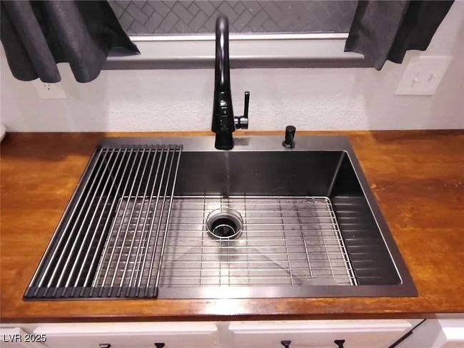 Kitchen view of a sink and wooden counters | Image 8