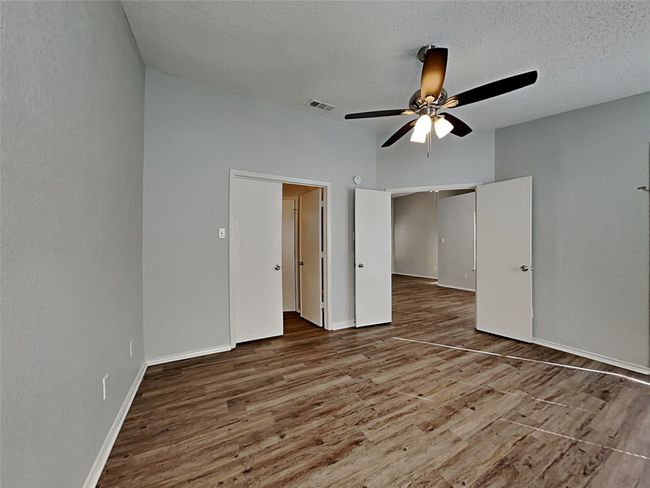 Unfurnished bedroom featuring wood finished floors, a textured ceiling, and ceiling fan | Image 9