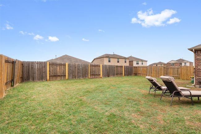 View of yard featuring a fenced backyard and re-established bermuda grass. | Image 28