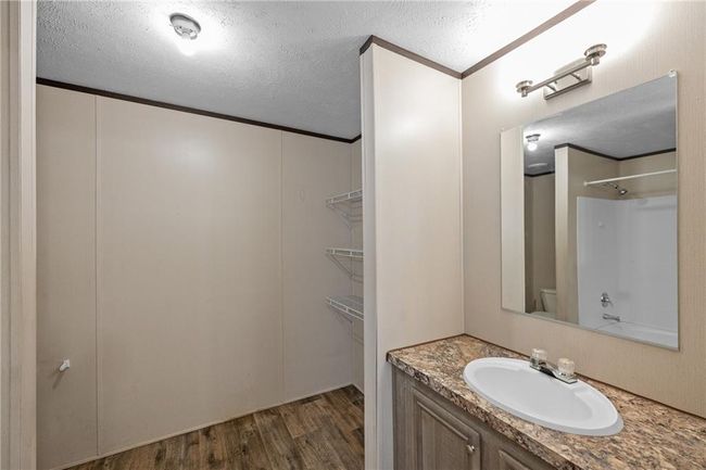 Full bath with vanity, wood finished floors, a textured ceiling, toilet, and ornamental molding | Image 27