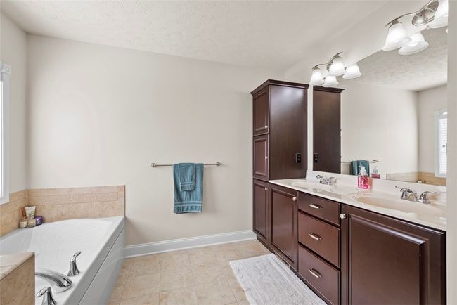The master bathroom provides a dual vanity and tall built in linen/vanity closet for all of those extras. | Image 27