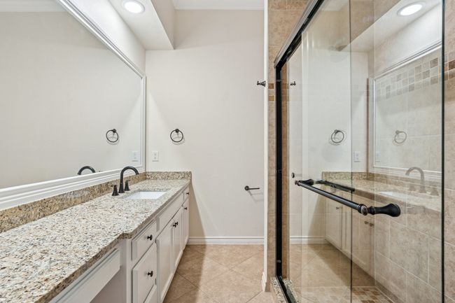 Bathroom with vanity, a stall shower, and tile patterned flooring | Image 19