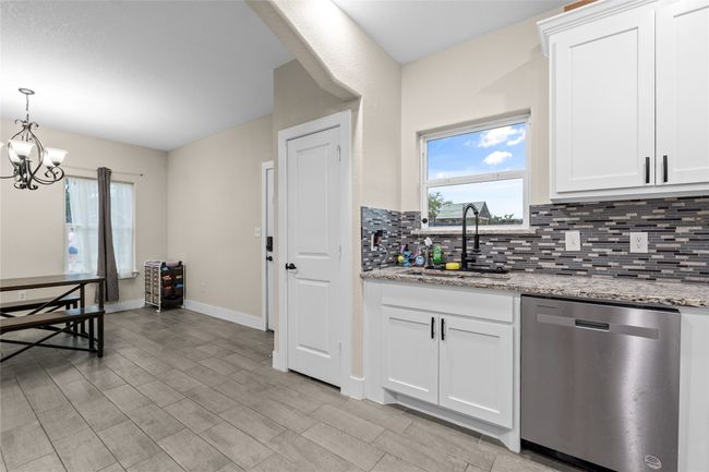 Kitchen with dishwasher, backsplash, a chandelier, and plenty of natural light | Image 24