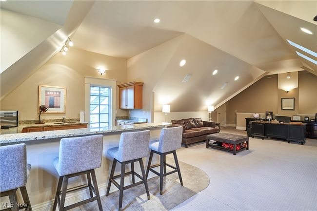 Over the garage is large room with a Kitchen with granite counters , a breakfast bar, vaulted ceiling, and skylights | Image 26
